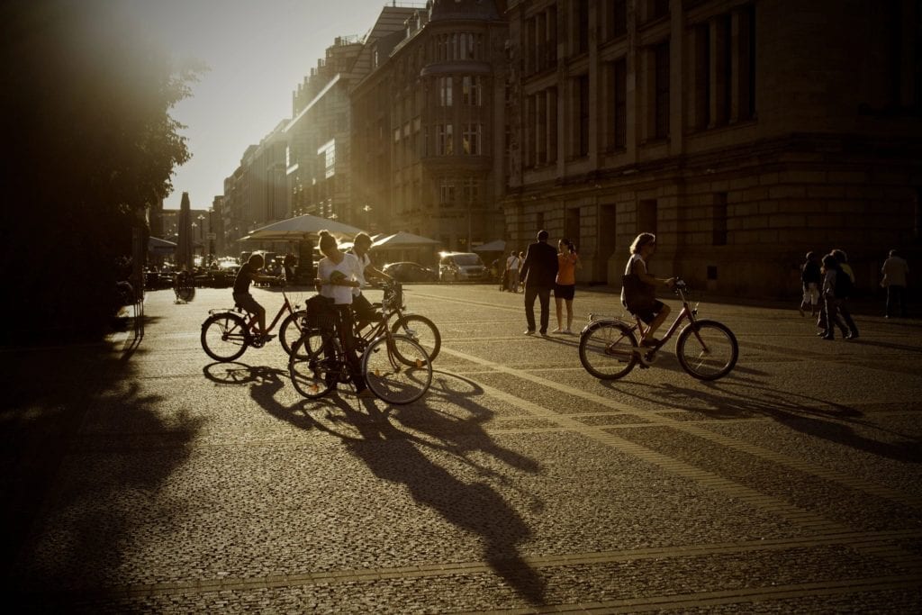 View of people on bicycles with sun rays